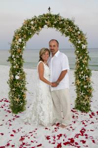 Our nautical beach wedding arch design is covered with starfish and seashells